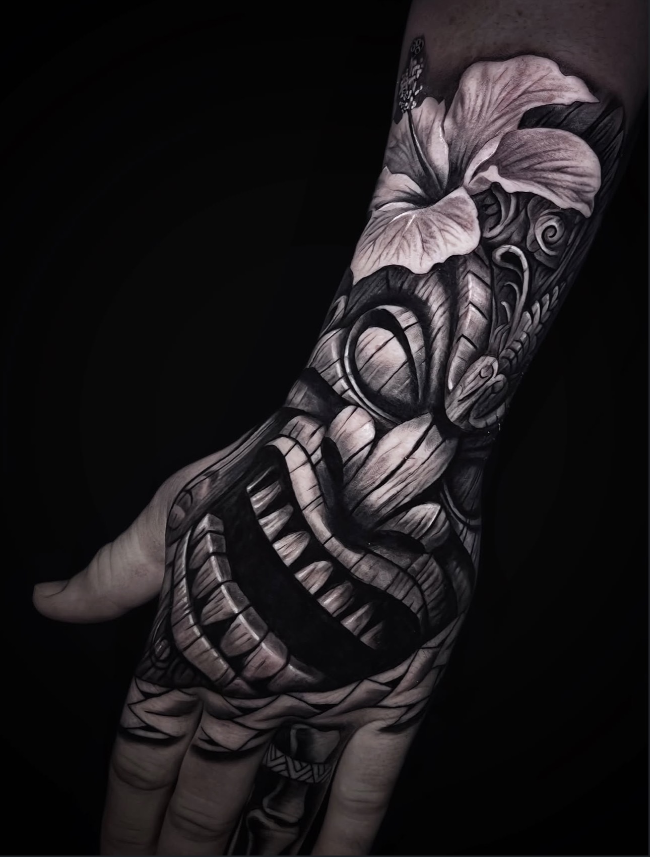 Black and grey Polynesian and hibiscus hand tattoo
