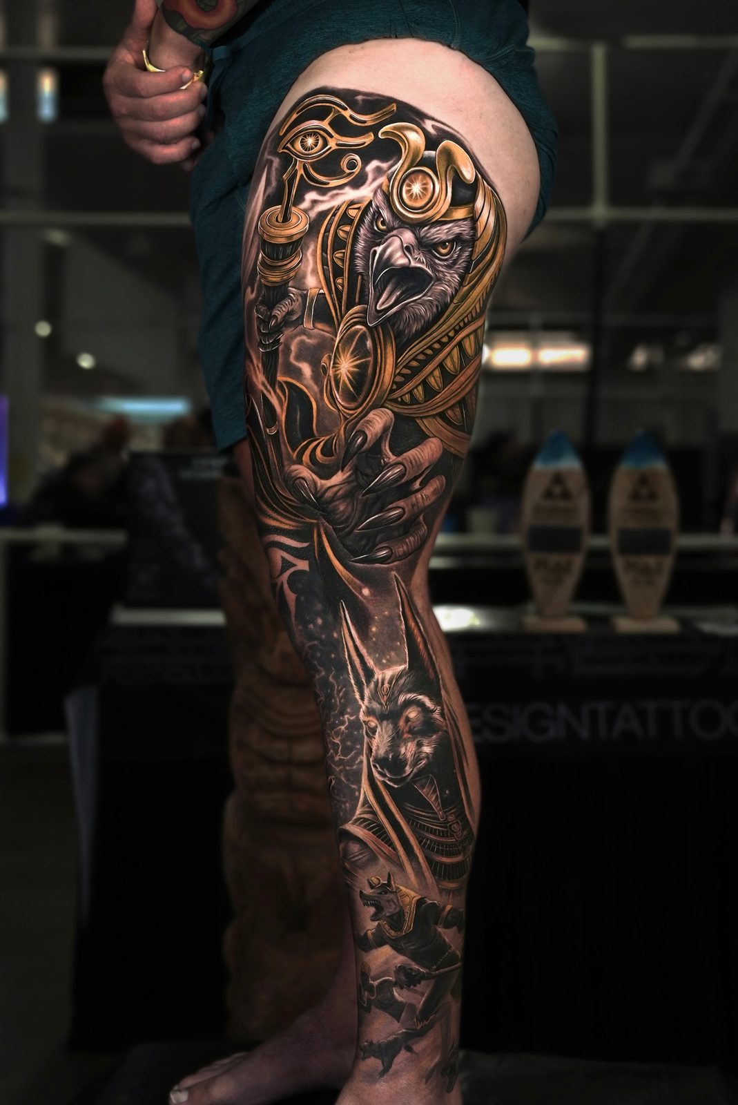 Black and grey realism Egyptian god Horus leg sleeve tattoo with gold accents