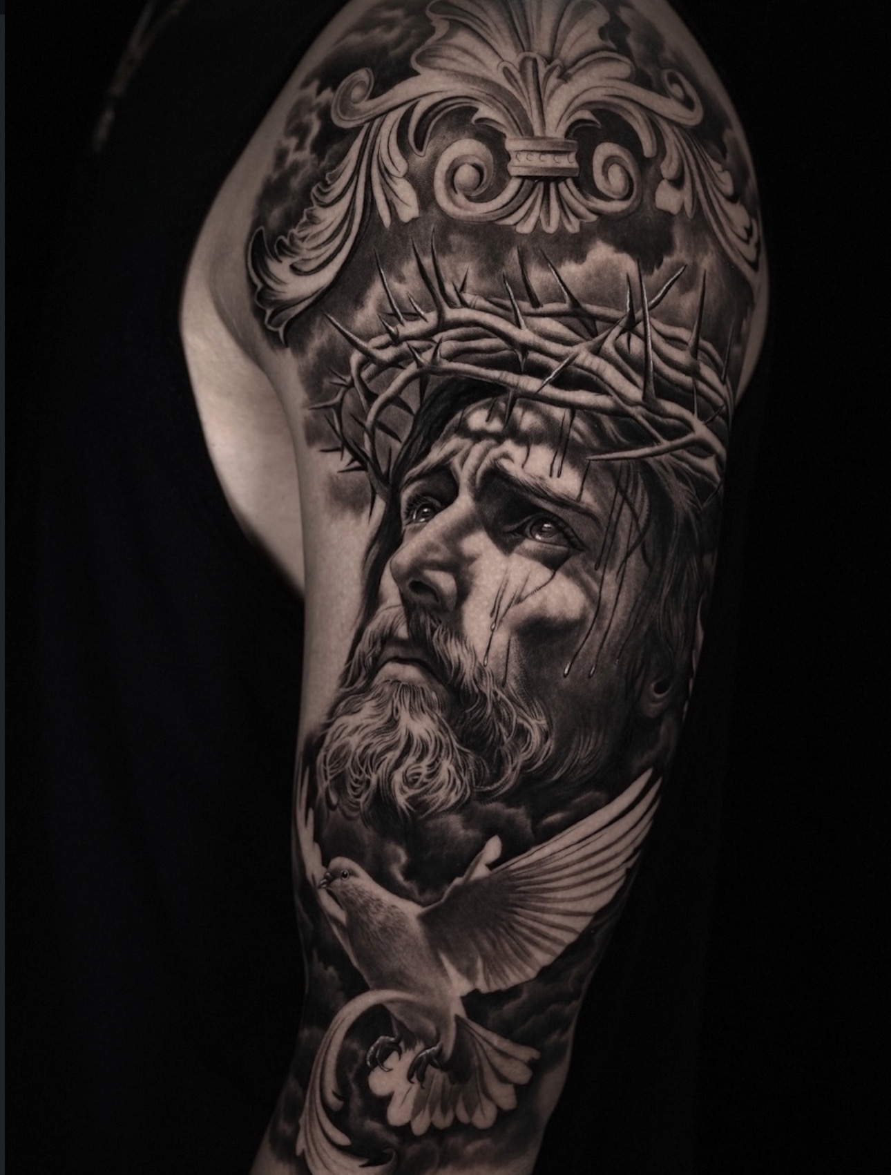 Black and grey realism Jesus with crown of thorns and dove half sleeve tattoo