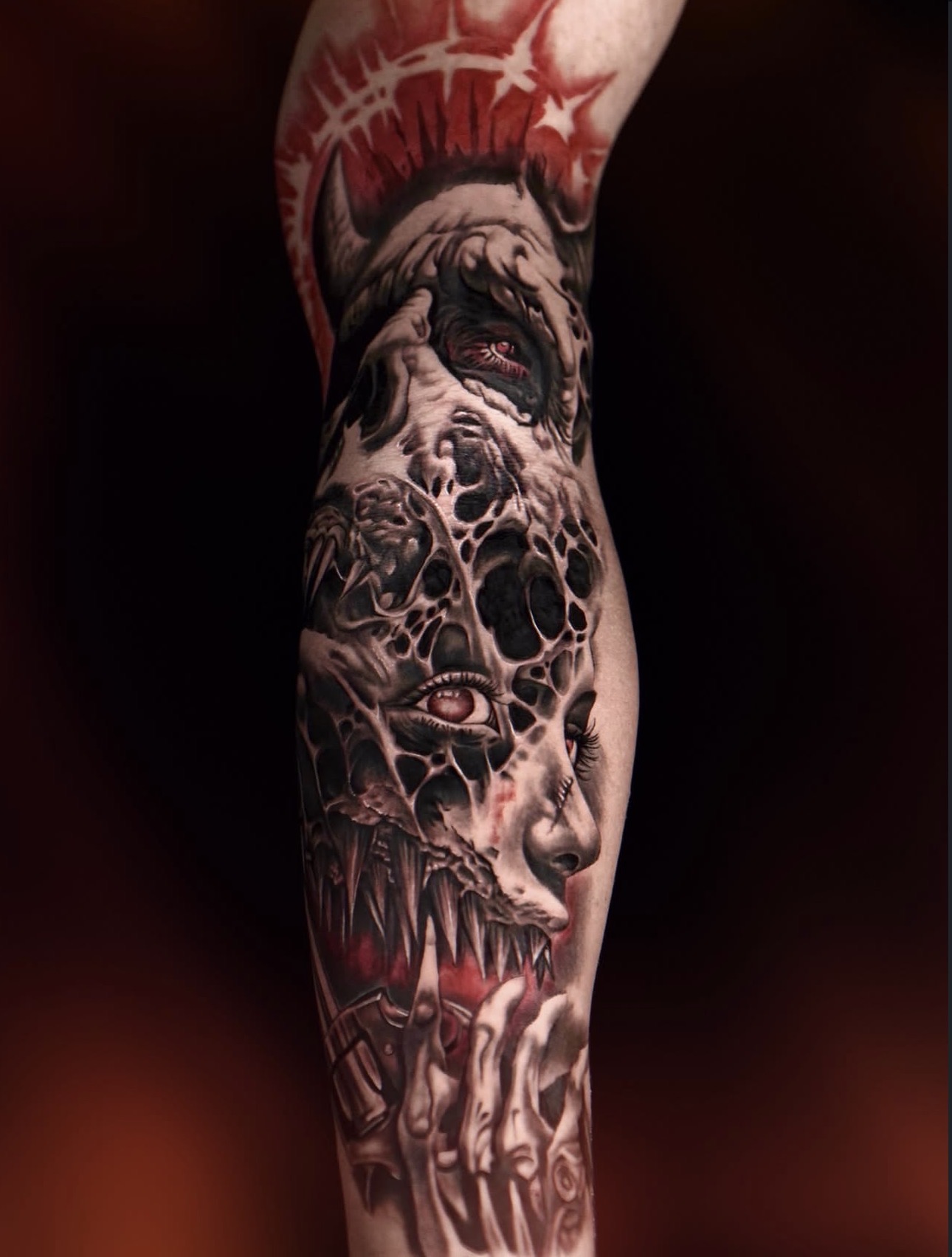 Dark realism biomechanical portrait leg sleeve tattoo with red accents