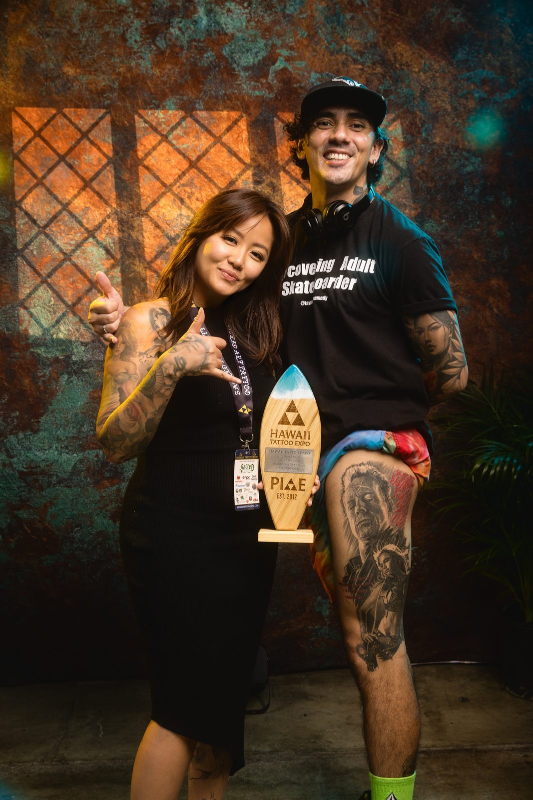 Lynn Hoang and a client holding a Hawaii Tattoo Expo trophy